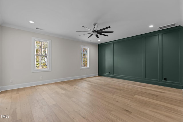 empty room with light hardwood / wood-style floors, ceiling fan, plenty of natural light, and ornamental molding