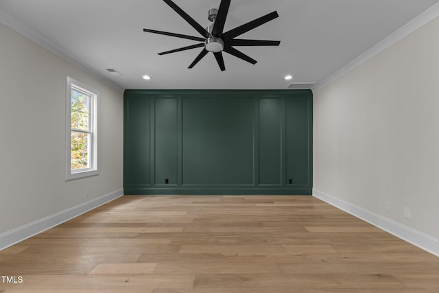 empty room with ornamental molding, light hardwood / wood-style flooring, and ceiling fan