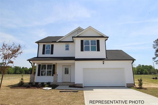 craftsman-style house featuring concrete driveway and a front lawn