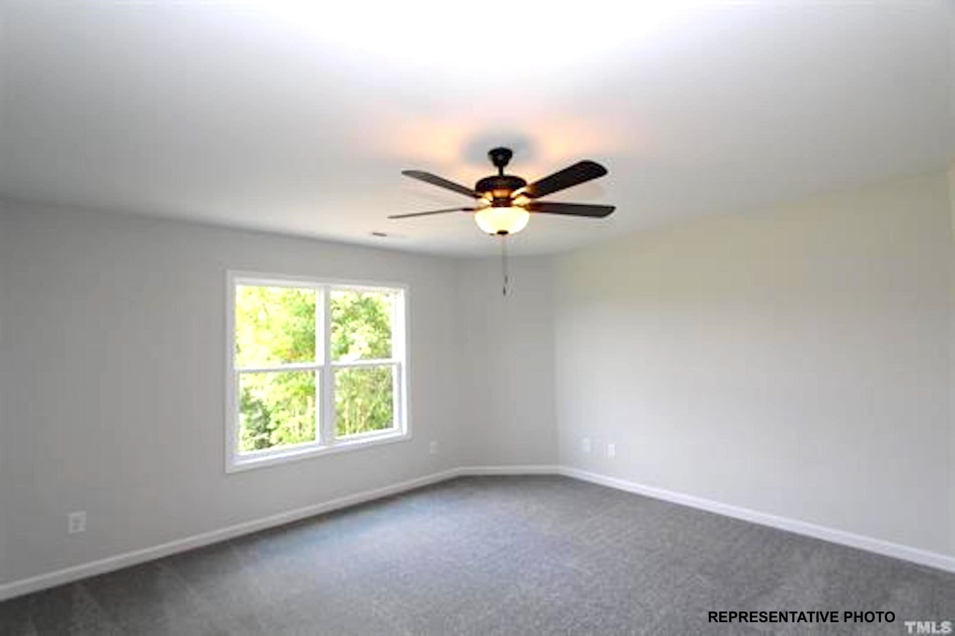 unfurnished room with dark carpet, a ceiling fan, and baseboards