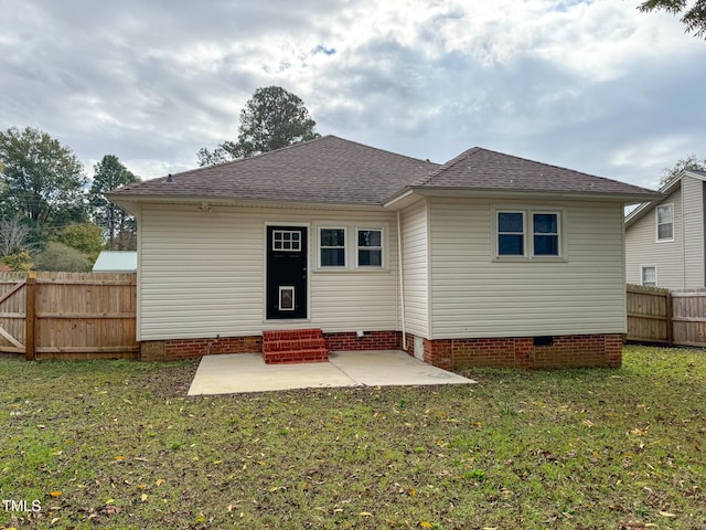 back of house featuring a lawn and a patio