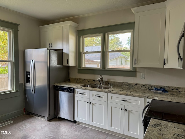 kitchen with stainless steel appliances, light stone countertops, white cabinetry, and sink