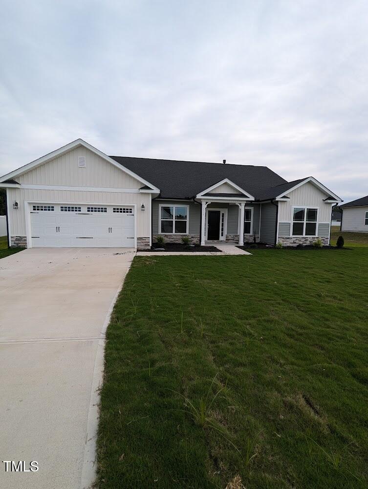 ranch-style house featuring a garage and a front yard