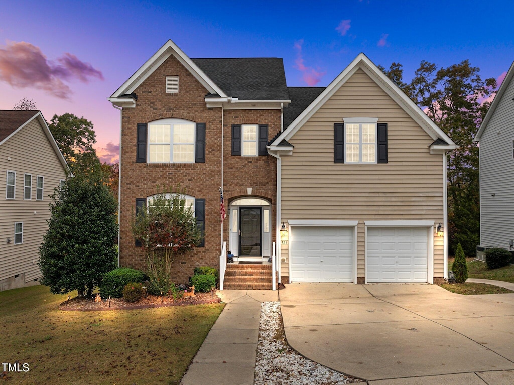 front facade with a garage and a lawn