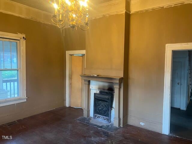 unfurnished living room with a fireplace, crown molding, and an inviting chandelier