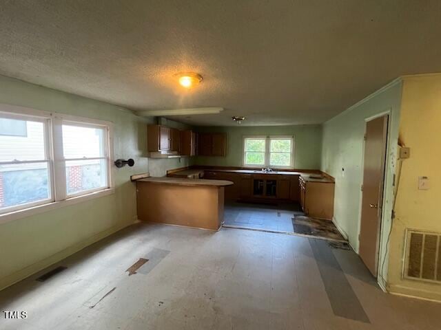 kitchen with kitchen peninsula and a textured ceiling