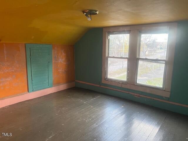 additional living space with dark hardwood / wood-style flooring and lofted ceiling