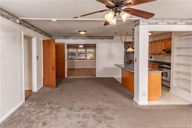 kitchen with ceiling fan, a textured ceiling, and stainless steel range with gas stovetop