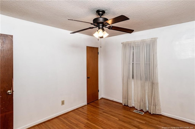 spare room featuring ceiling fan, a textured ceiling, and hardwood / wood-style floors