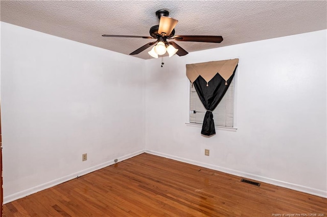 empty room featuring hardwood / wood-style flooring, a textured ceiling, and ceiling fan