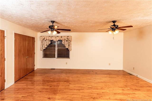 unfurnished room with a textured ceiling and light hardwood / wood-style floors