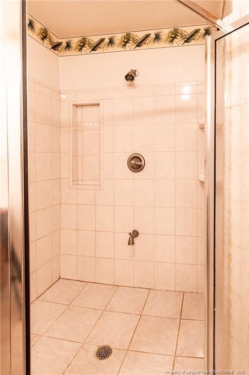 bathroom featuring a textured ceiling and a tile shower