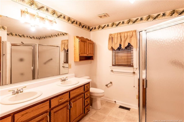 bathroom featuring a textured ceiling, an enclosed shower, vanity, and toilet