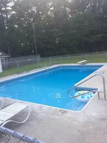 view of swimming pool featuring a fenced in pool, fence, and a patio