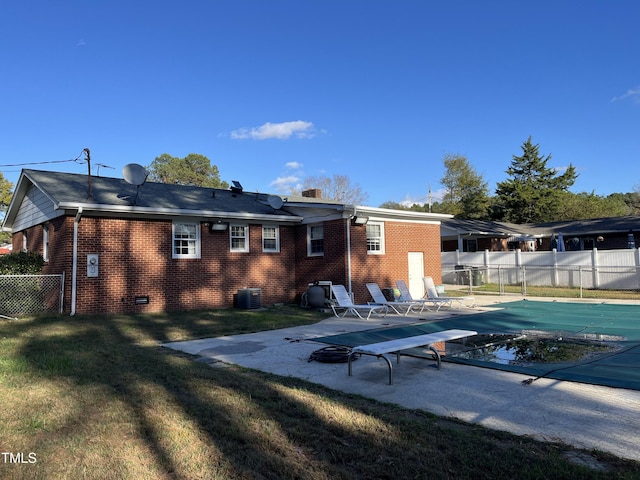 rear view of house featuring brick siding, crawl space, a patio area, and fence