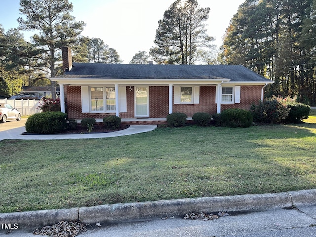 single story home with brick siding, a chimney, a front lawn, and fence