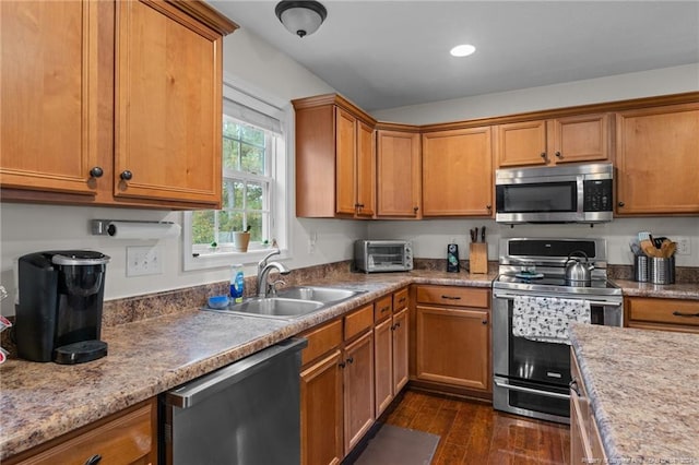 kitchen with dark wood-type flooring, appliances with stainless steel finishes, sink, and light stone counters