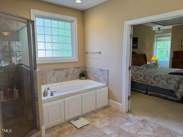 bathroom with a healthy amount of sunlight and separate shower and tub