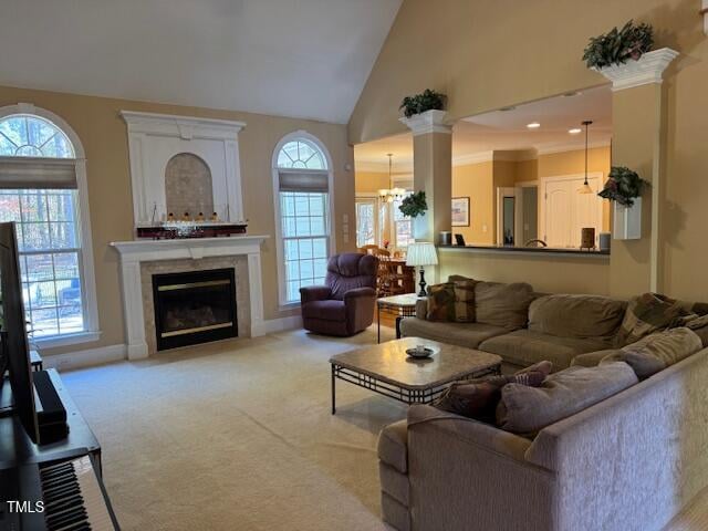 carpeted living room featuring high vaulted ceiling, a notable chandelier, and plenty of natural light