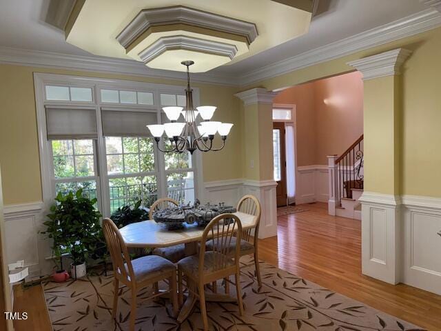2012 Silverleaf Dr, Youngsville, NC 27596 - dining space featuring a chandelier, light wood-type flooring, healthy amount of natural light, wainscoting, and crown molding