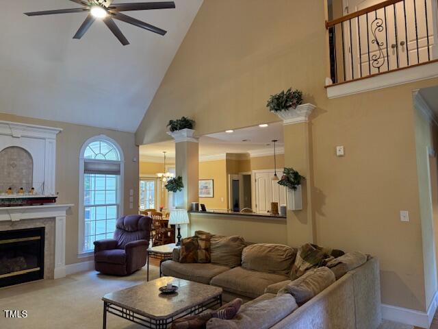 living room with high vaulted ceiling, light colored carpet, and ceiling fan