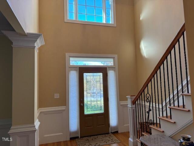 foyer featuring a wealth of natural light, a high ceiling, and light hardwood / wood-style flooring