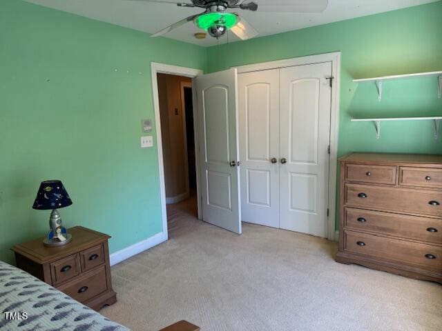 unfurnished bedroom with a closet, light colored carpet, and ceiling fan