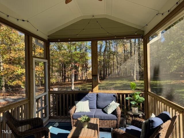 sunroom / solarium with plenty of natural light, ceiling fan, and vaulted ceiling