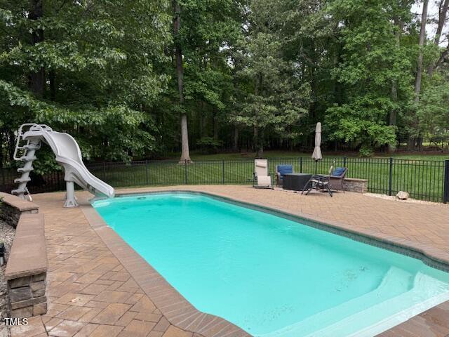 2012 Silverleaf Dr, Youngsville, NC 27596 - view of pool featuring a water slide, a patio area, and view of scattered trees