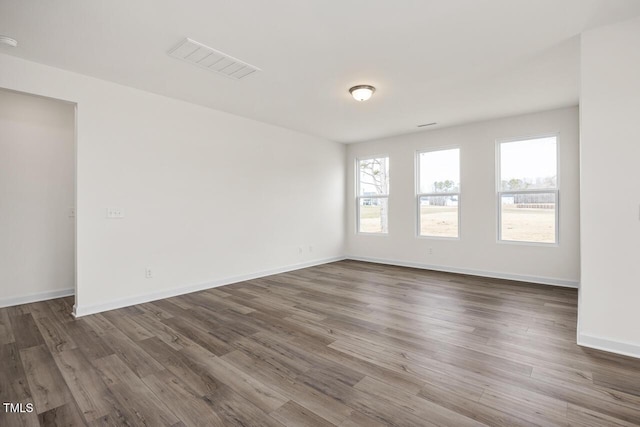 unfurnished room with dark hardwood / wood-style floors and a wealth of natural light