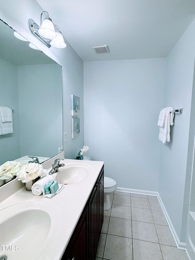 bathroom featuring tile patterned floors, vanity, toilet, and a tub