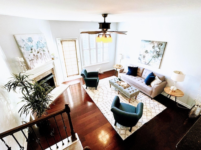 living room featuring ceiling fan, wood-type flooring, and a fireplace