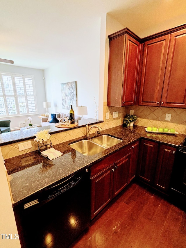 kitchen featuring sink, dark wood-type flooring, tasteful backsplash, dark stone counters, and black appliances