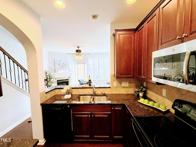 kitchen with tasteful backsplash, ceiling fan, sink, black appliances, and dark stone countertops