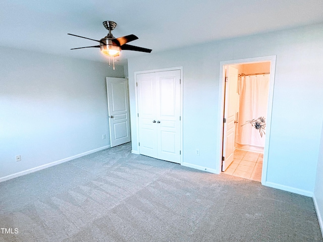 unfurnished bedroom with ensuite bath, ceiling fan, and light carpet