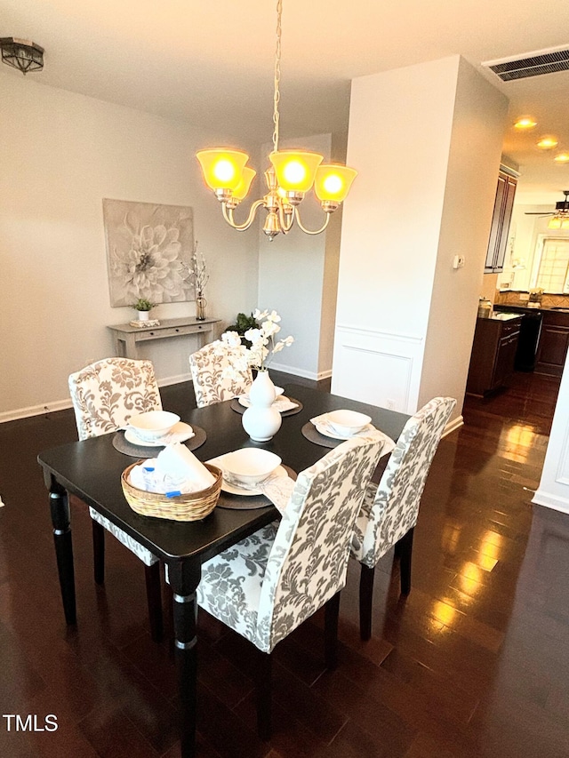 dining room with dark hardwood / wood-style floors and a notable chandelier