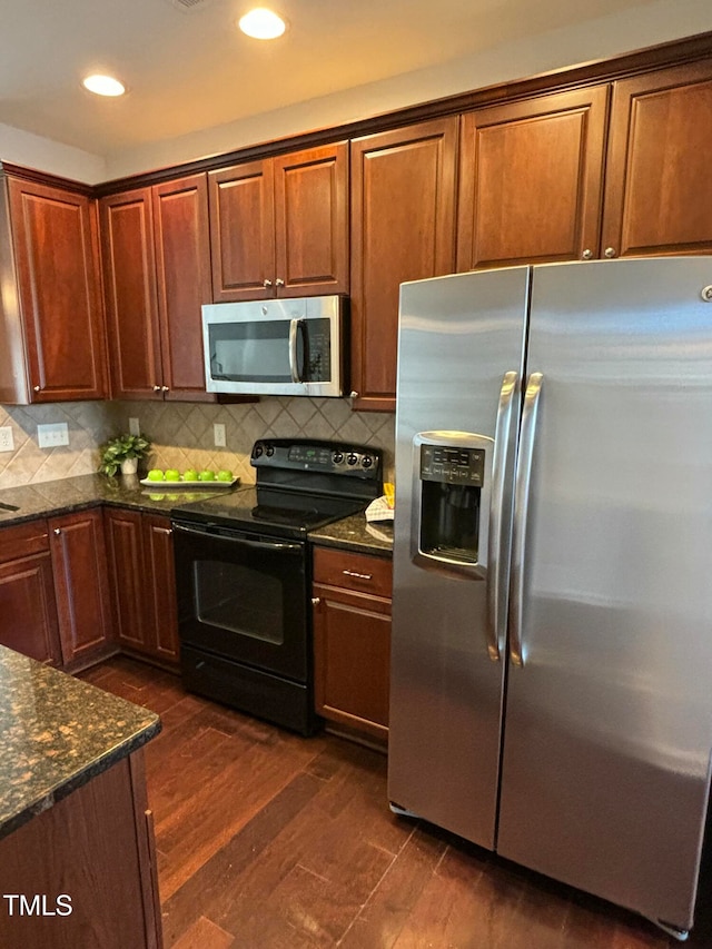 kitchen with dark stone counters, decorative backsplash, stainless steel appliances, and dark hardwood / wood-style floors