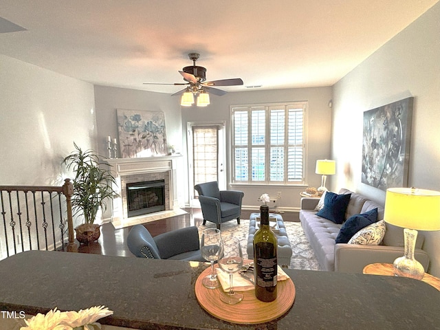 living room with ceiling fan and a fireplace