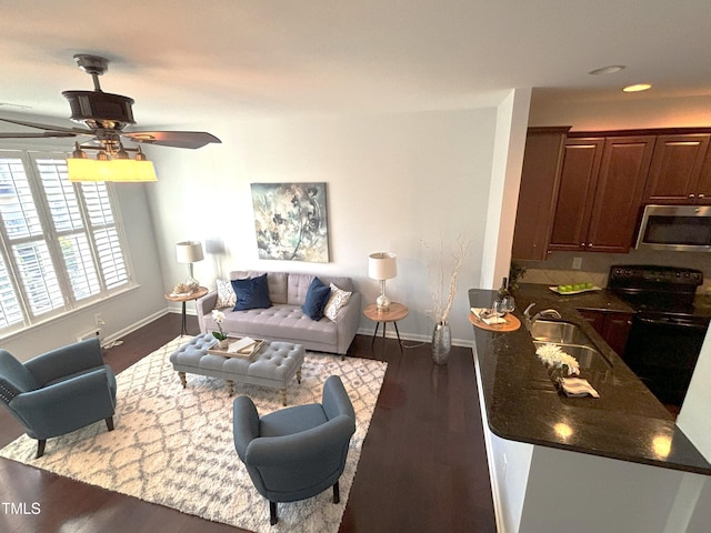 living room featuring ceiling fan, dark hardwood / wood-style floors, and sink