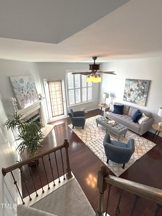 living room with a fireplace, wood-type flooring, and ceiling fan