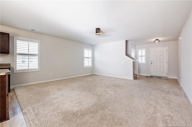 5918 Lowgrass Rd, Stedman, NC 28391 - unfurnished living room featuring baseboards and light colored carpet