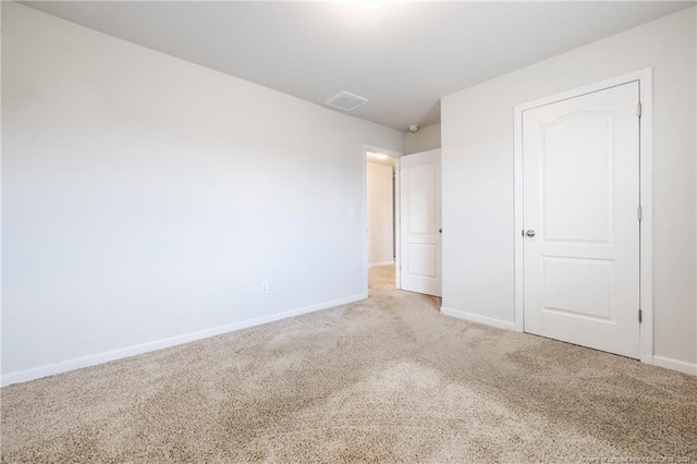 unfurnished bedroom featuring light colored carpet and a closet