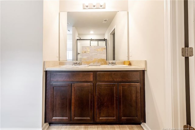 bathroom featuring walk in shower, vanity, and hardwood / wood-style flooring