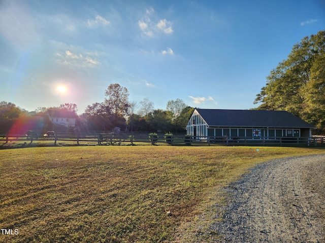 view of front facade with a rural view and a front lawn