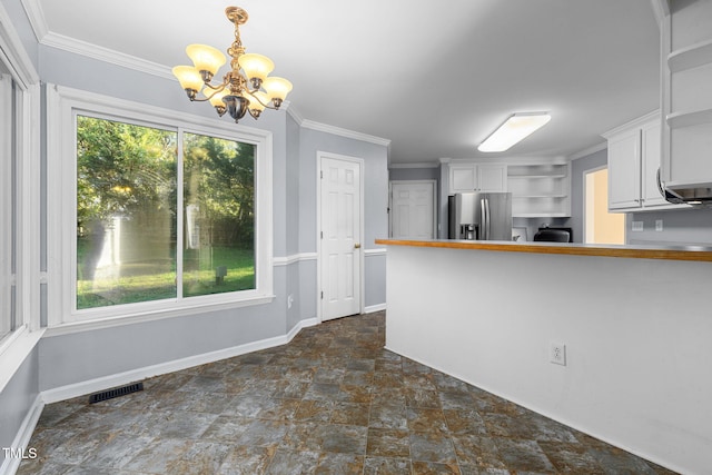 kitchen featuring ornamental molding, stainless steel fridge, white cabinetry, decorative light fixtures, and a chandelier