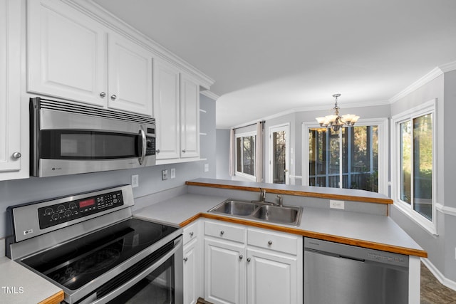 kitchen with stainless steel appliances, white cabinetry, a notable chandelier, pendant lighting, and sink