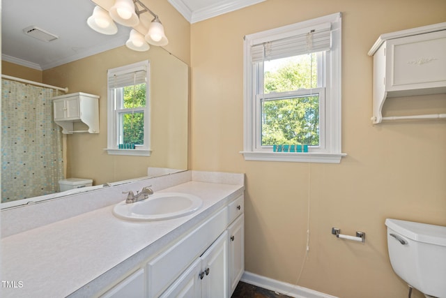 bathroom with toilet, plenty of natural light, vanity, and crown molding