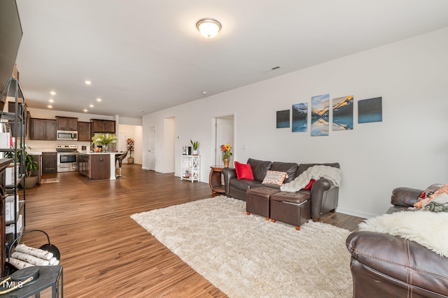 living room featuring visible vents, wood finished floors, and recessed lighting