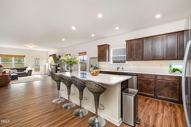 kitchen featuring dishwasher, a breakfast bar area, a wealth of natural light, and a center island