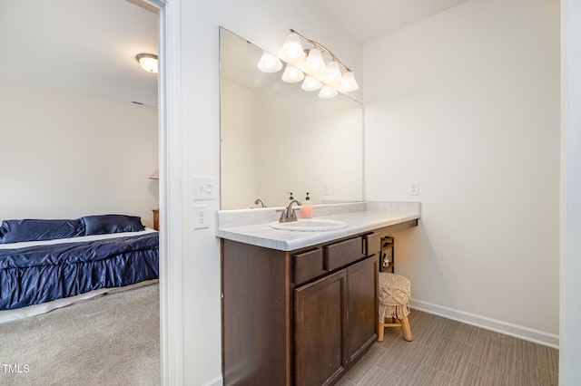 bathroom featuring vanity, baseboards, and ensuite bathroom